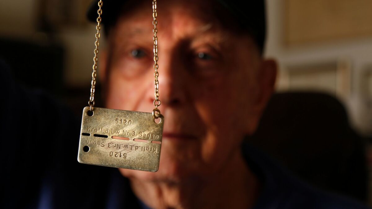Stuart Hunt, 93, holds the POW camp identification he wore during his time as a POW during WWII.