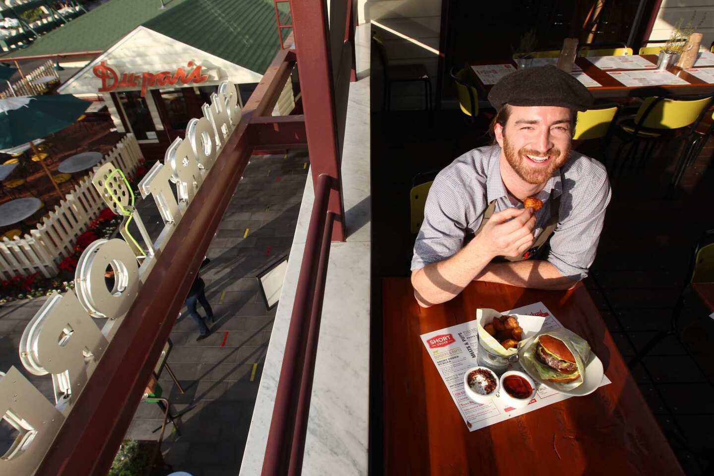 Short Order chef Christian Page dines on the restaurant's specialty "spuds" and a burger on the upstairs terrace.