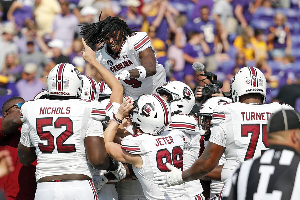 South Carolina's Cam Smith (9) jumps on top of teammates celebrating their win over East Carolina at an NCAA college football game in Greenville, N.C., Saturday, Sept. 11, 2021. (AP Photo/Karl B DeBlaker)