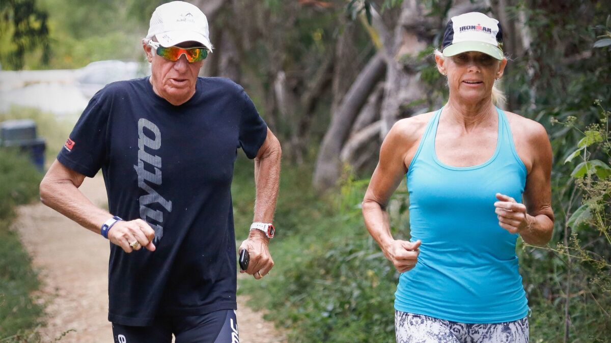 Mike Levine, 68, of Carlsbad and Kathleen McCartney, 58, of La Jolla go for a training run to prepare for the 2017 Ironman World Championship in Kona, Hawaii, on Oct. 18. Levine has stage 4 pancreatic cancer.