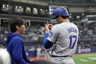 Dodgers designated hitter Shohei Ohtani talks to his interpreter Ippei Mizuhara during a game against the Padres