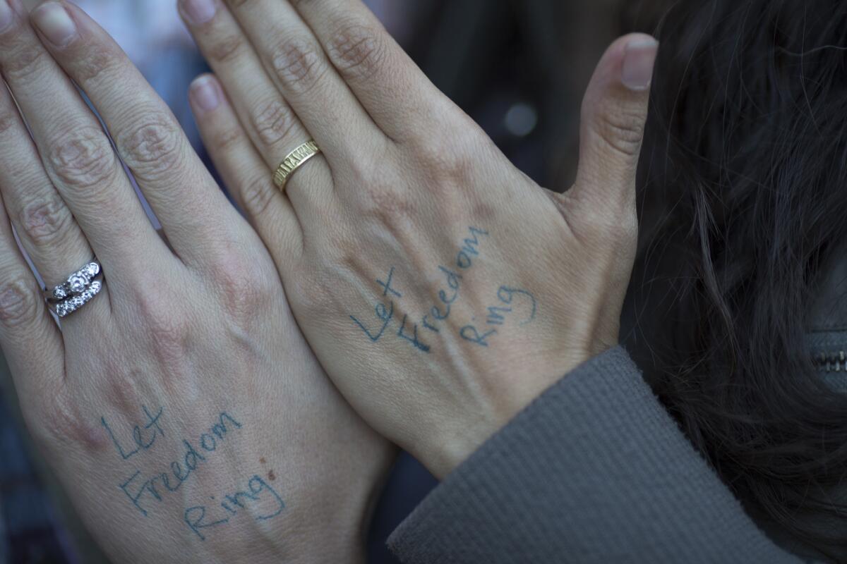 A couple show their wedding rings as they celebrate the Supreme Court ruling on same-sex marriage on June 26, 2015, in West Hollywood. Some say the ruling threatens religious freedom.