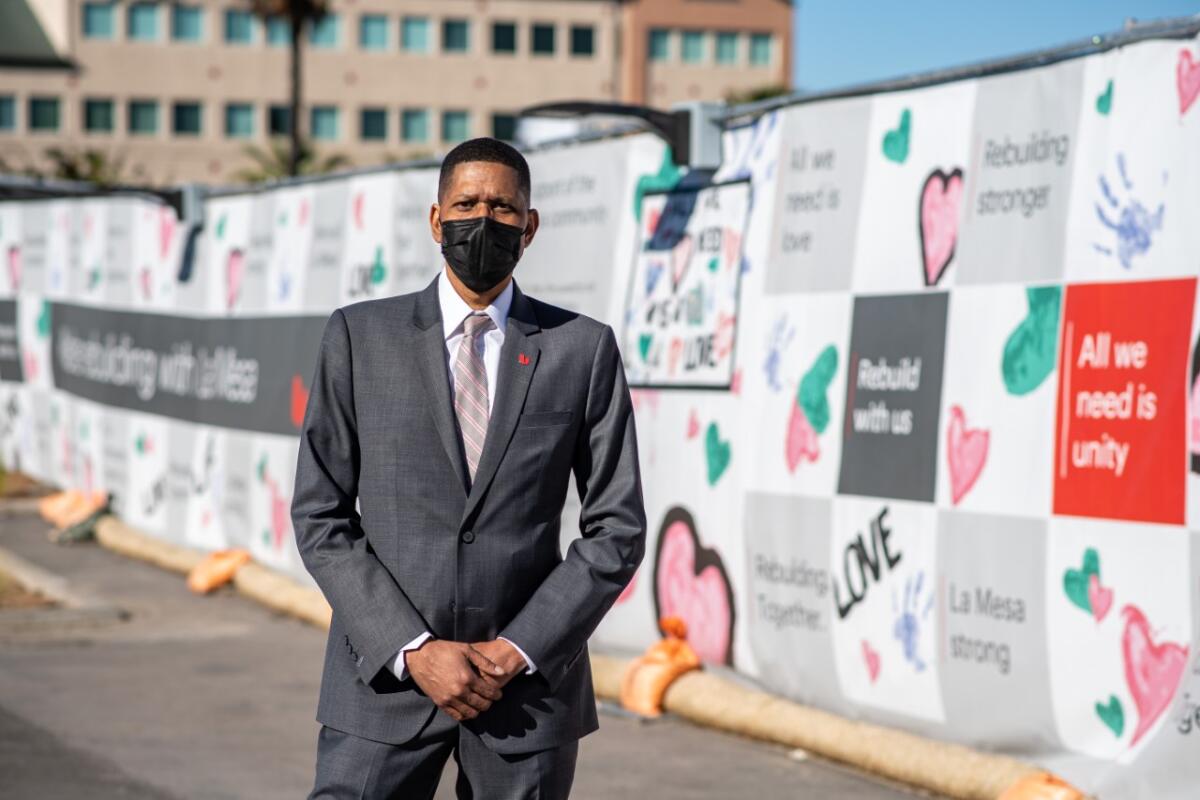 Carlton Hill, manager of Union Bank in La Mesa, stands by the art-decorated fence around the former building.