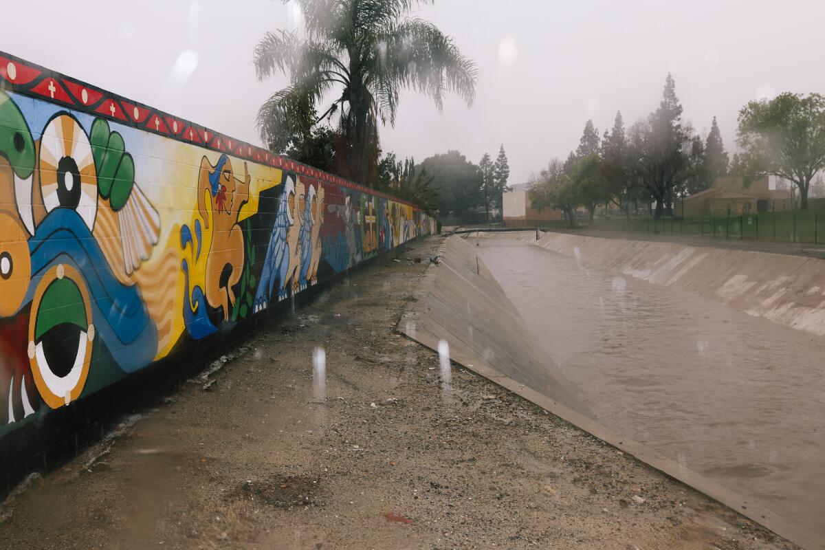 Water rushes through a flood control-channel on Tuesday in Placentia