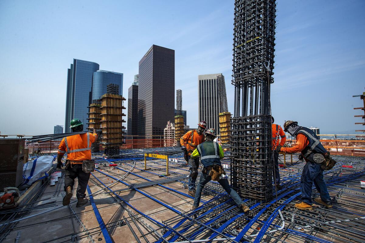 Iron workers set columns made out of rebar for the Grand's residential tower.