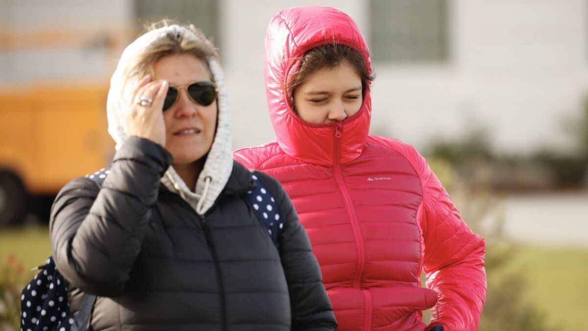 Lourdes DeZavalia, 15, with her mom, Veronica, visiting from Argentina, brave the cold at the Griffith Observatory on February 21, 2019, as a cold front passes through the Southland.