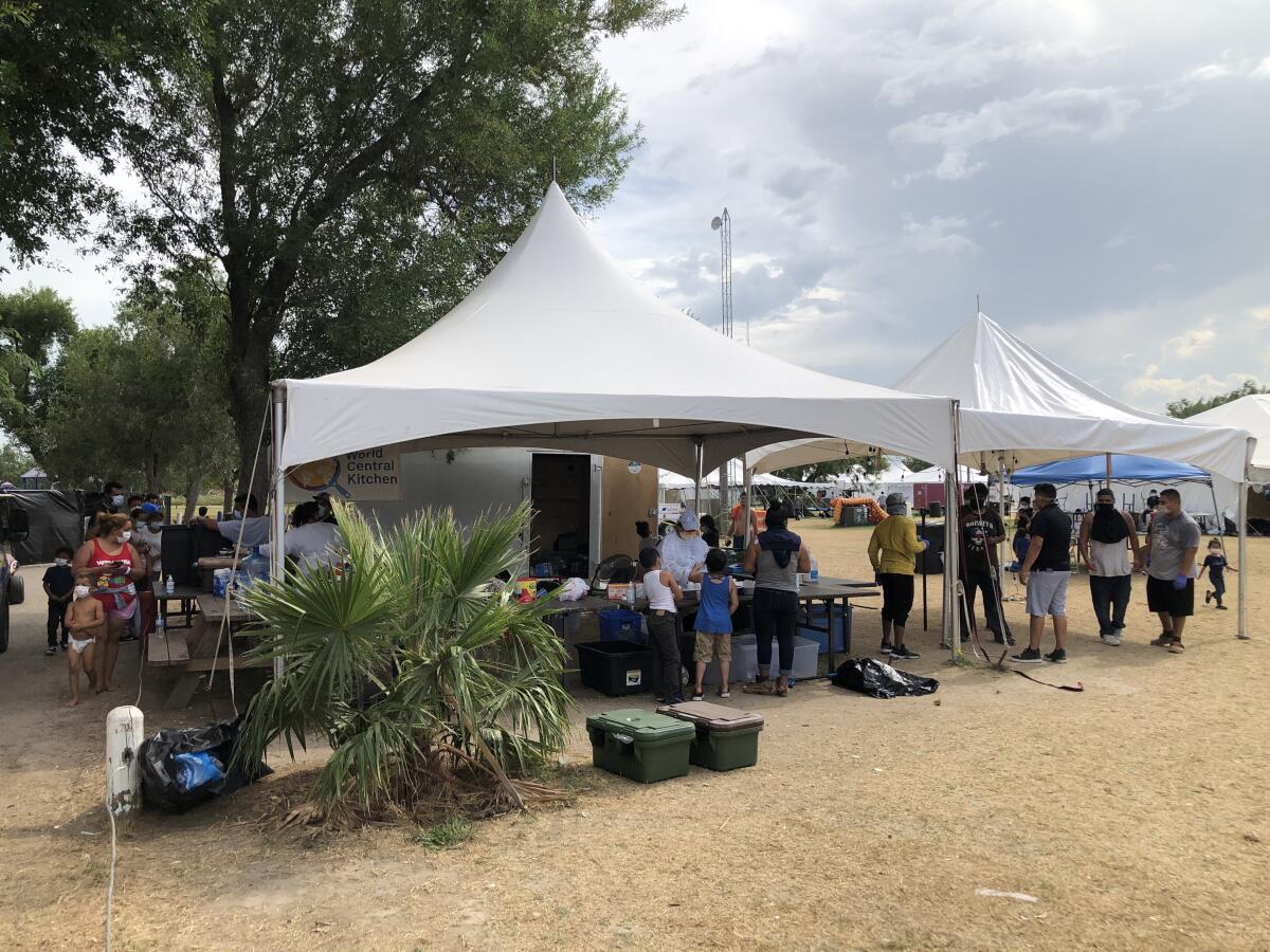 People stand under tents outdoors