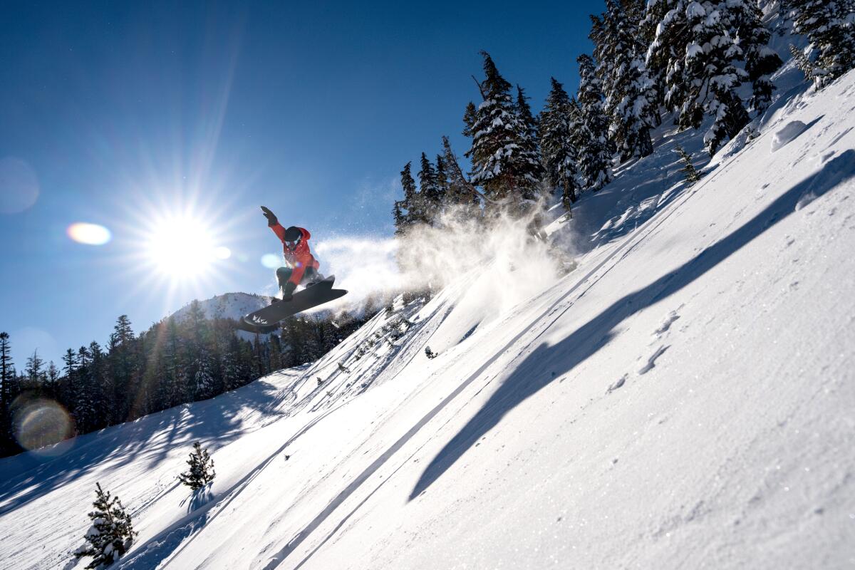 A snowboarder flies through the air while riding fresh powder on Mammoth Mountain