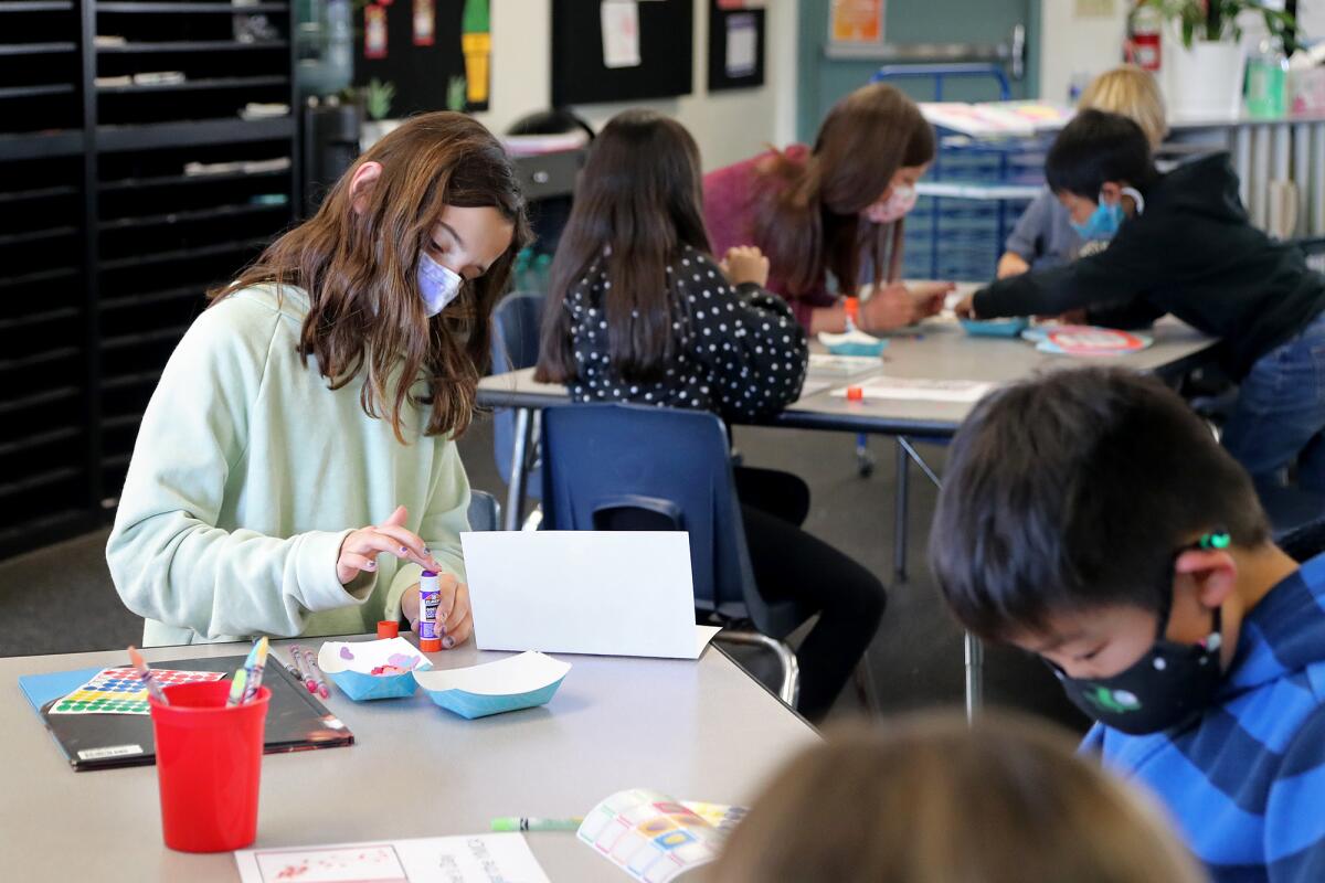 Fourth-grader Madison, 9, left, makes a valentines card for Meals on Wheels senior citizens on Wednesday.