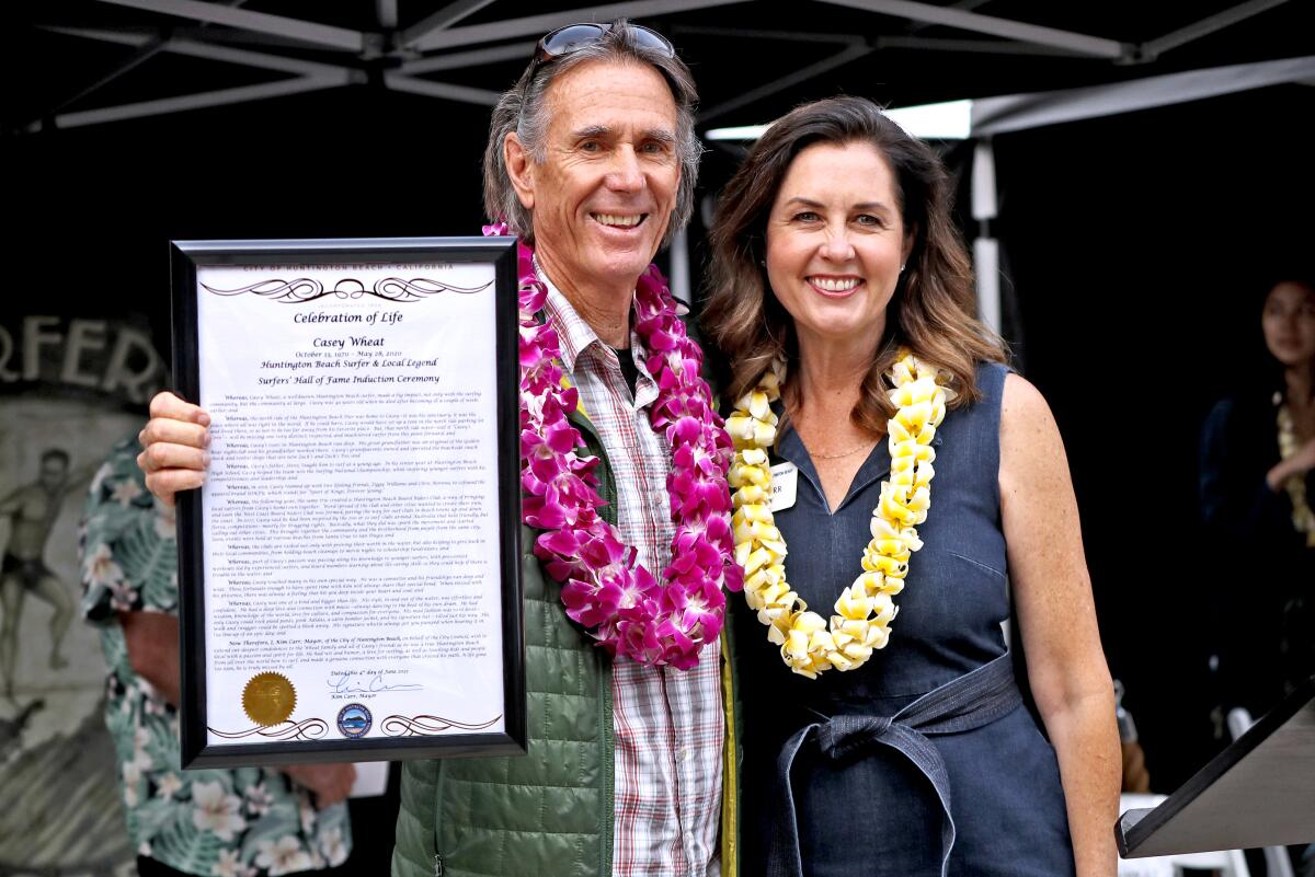 Steve Wheat, left, father of Surfers' Hall of Fame inductee Casey Wheat, with Huntington Beach Mayor Kim Carr on Friday.