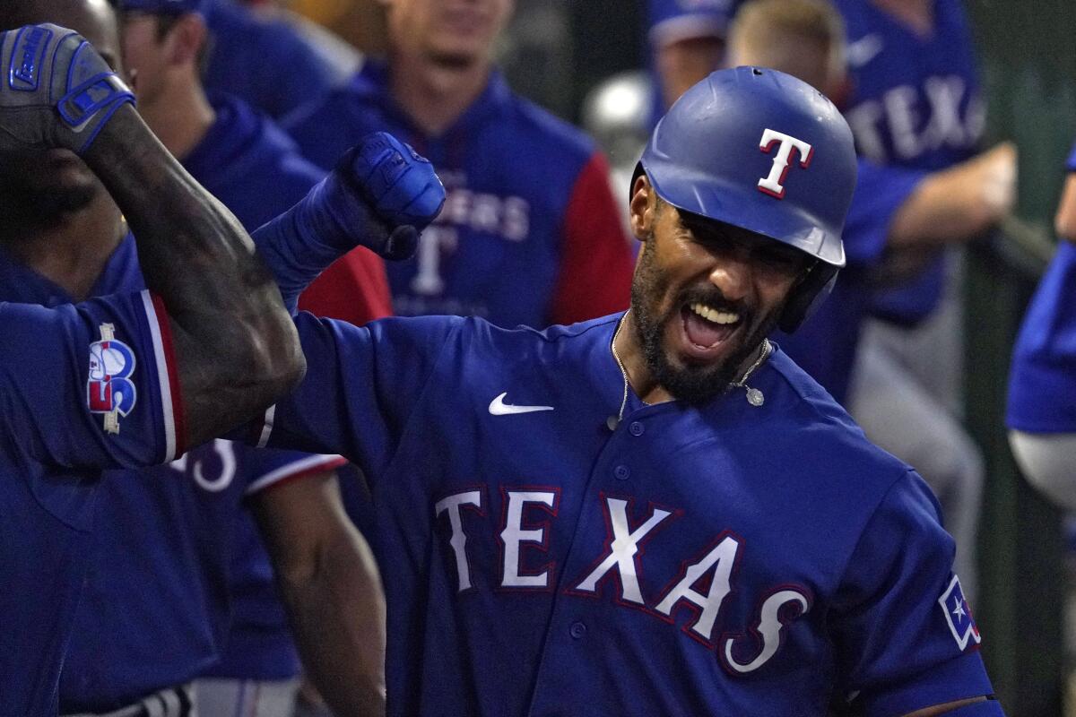 Marcus Semien celebrates with his Texas Rangers teammates after scoring against the Angels.