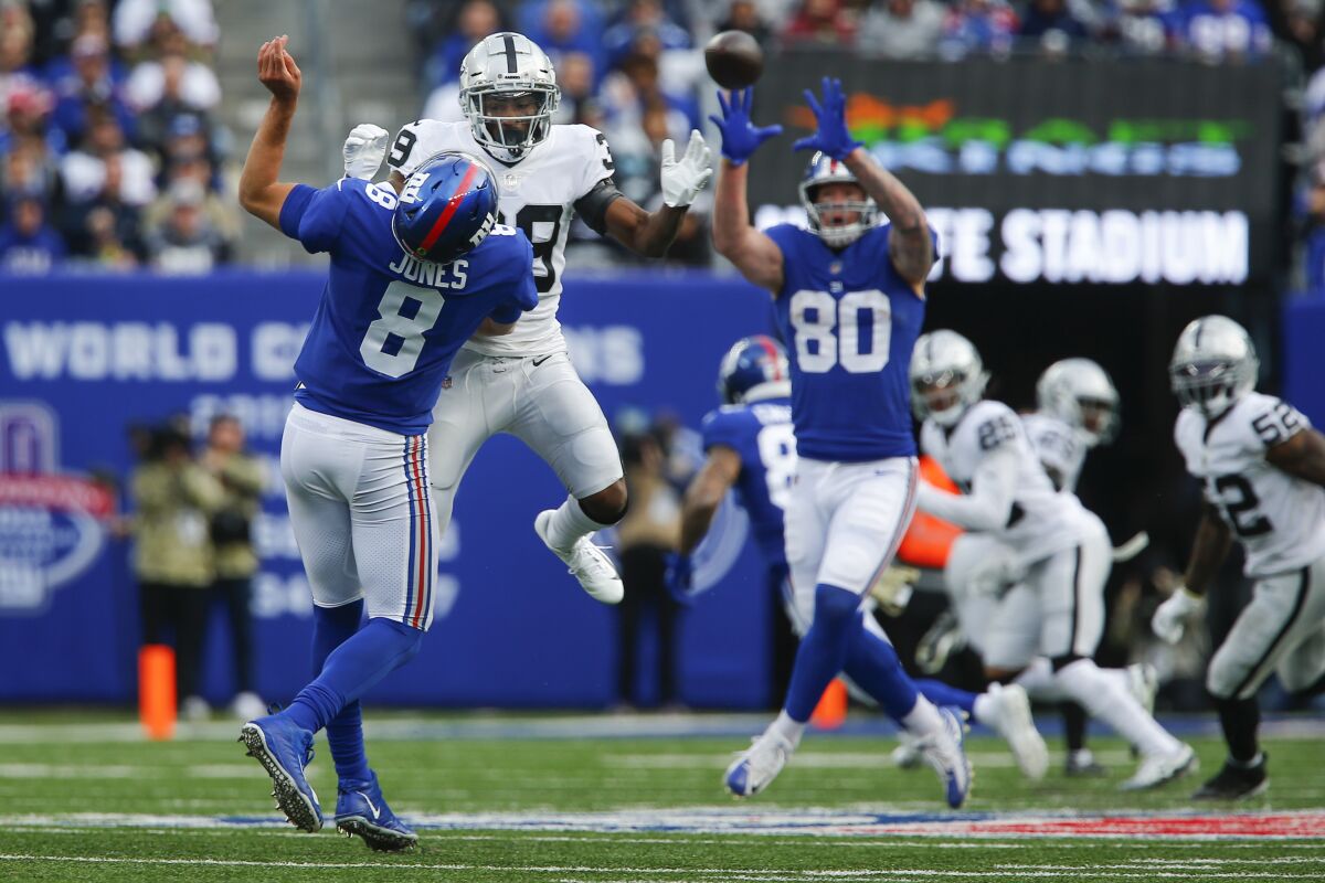 Las Vegas Raiders' Nate Hobbs (39) hits New York Giants' Daniel Jones (8) who throws to Kyle Rudolph (80) during the second half of an NFL football game Sunday, Nov. 7, 2021, in East Rutherford, N.J. Hobbs was penalized for roughing the passer on the play. (AP Photo/John Munson)