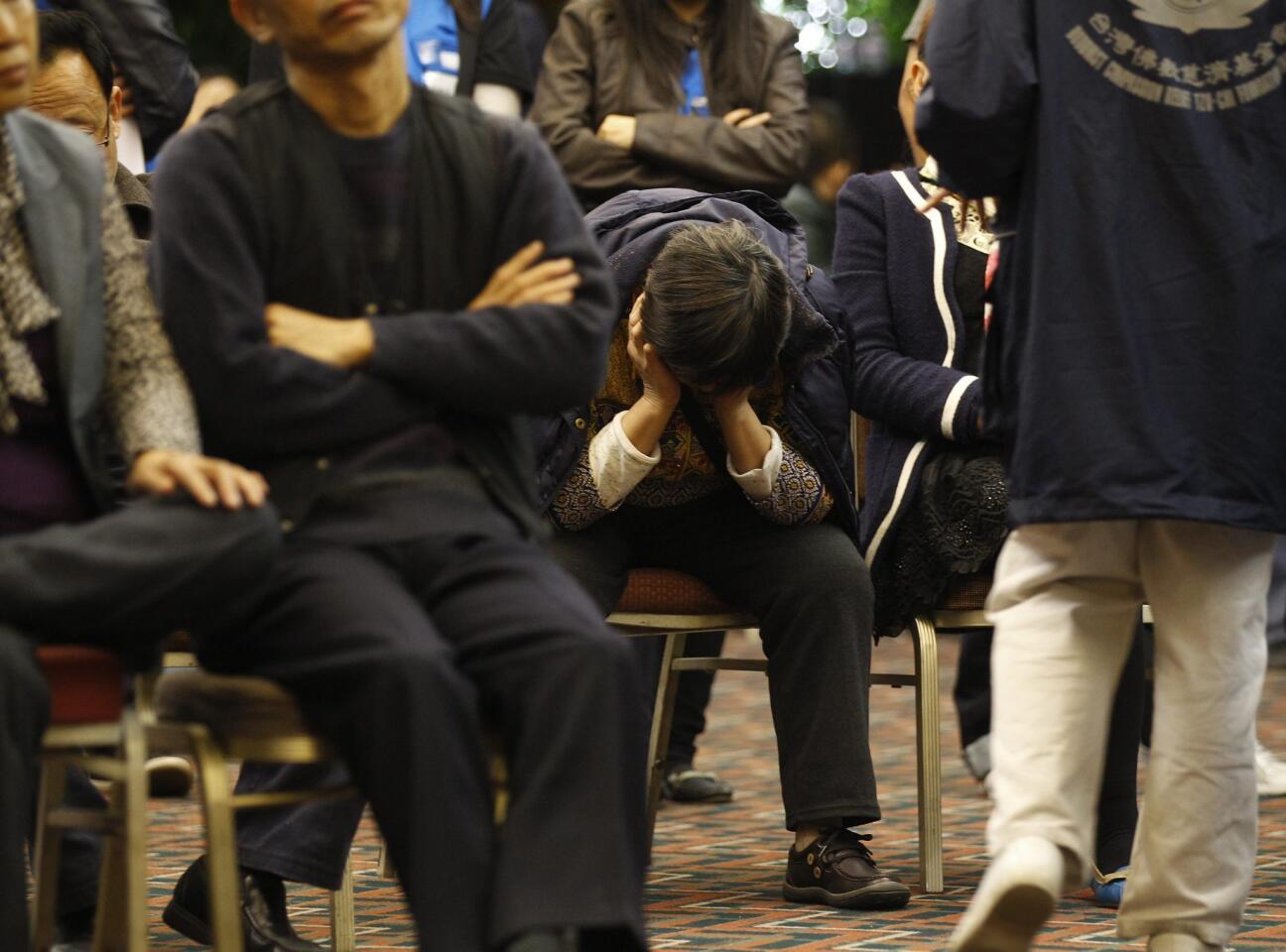 A relative of passengers of a missing Malaysia Airlines plane rests on a chair at a hotel meeting room in Beijing, China.