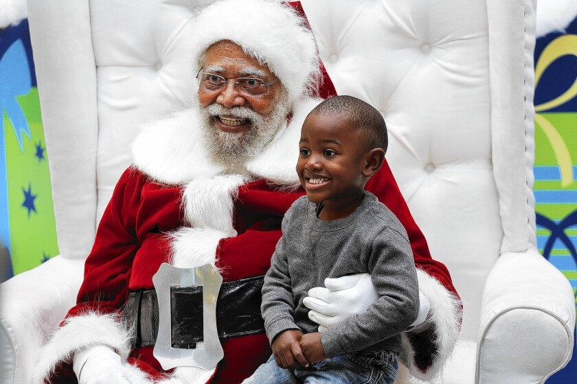 Jahleel Logan, 3, poses with Santa Claus, a.k.a. Langston Patterson, 77, at the Baldwin Hills Crenshaw Plaza. Patterson has been the South L.A. mall's Santa since 2004, with African American families coming at specific times of the day just to visit him. "I just don't want him to think that all greatness comes from a different race," said Jahleel's godmother, Arlene Graves, 45. "There are Santa Clauses his color doing good work too."