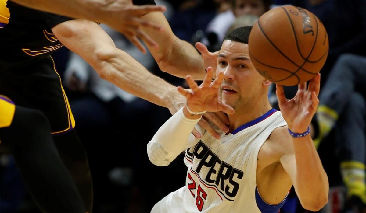 Clippers guard Austin Rivers, right, passes to a teammate after diving for a loose ball in the fourth quarter against the Lakers.