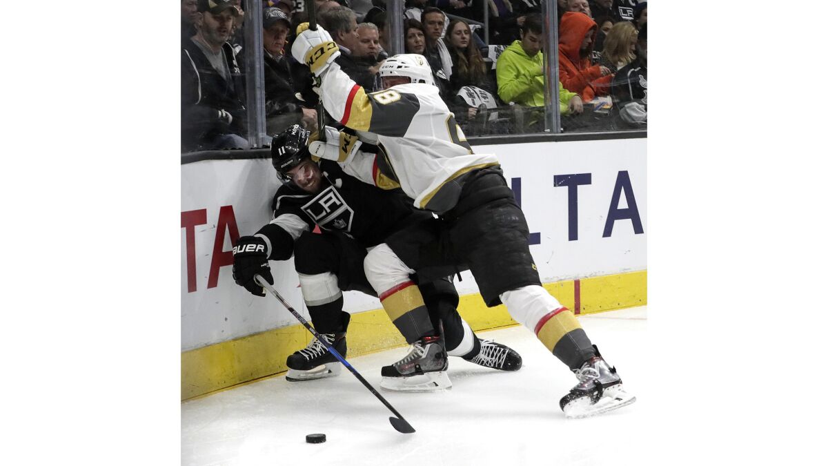 Kings center Anze Kopitar is checked off the puck by Golden Knights defenseman Nate Schmidt during first period action.