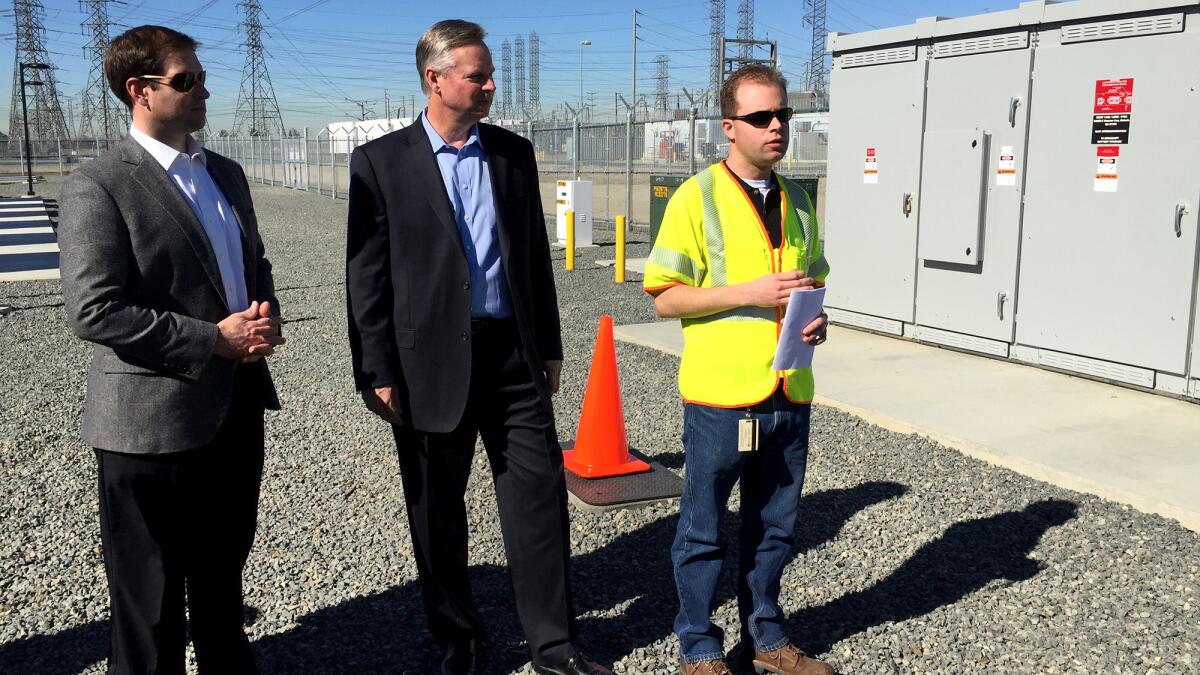 J.B Straubel, left, Tesla's chief technology officer, and Kevin Payne, Southern California Edison's CEO, provide a tour with a utility worker of Tesla's energy storage system at Edison's Mira Loma substation in Ontario.