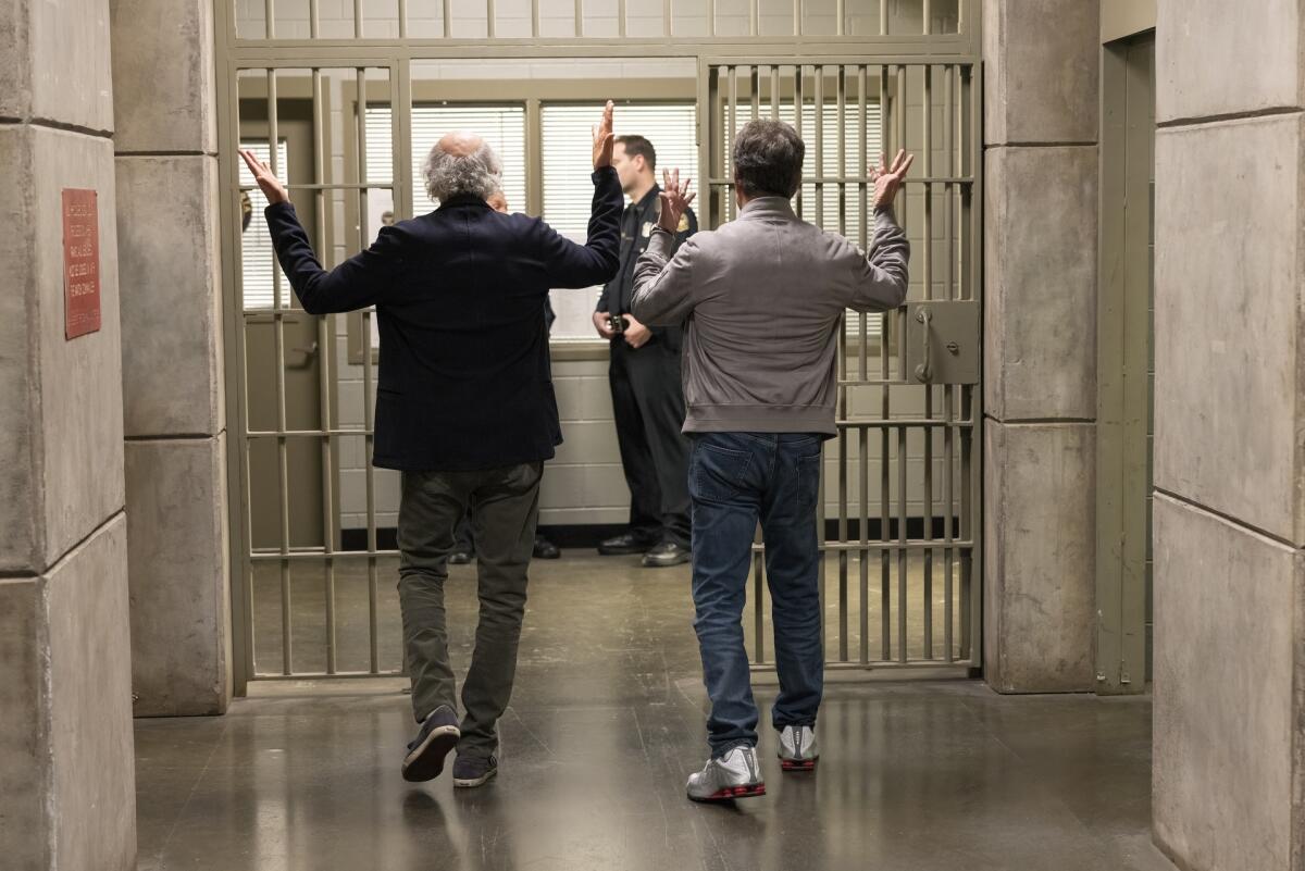 从后面看到两个男人走过监狱的走廊。