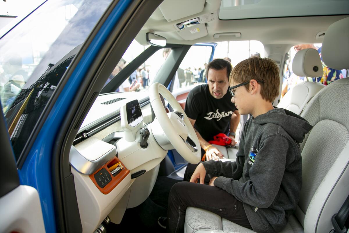 Owen Stockard and his dad, Brian, from Chino Hills, check out the Volkswagen ID.Buzz on Friday in Huntington Beach.