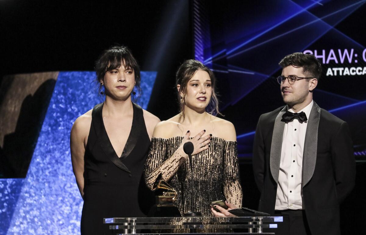 Three people accept an award on stage
