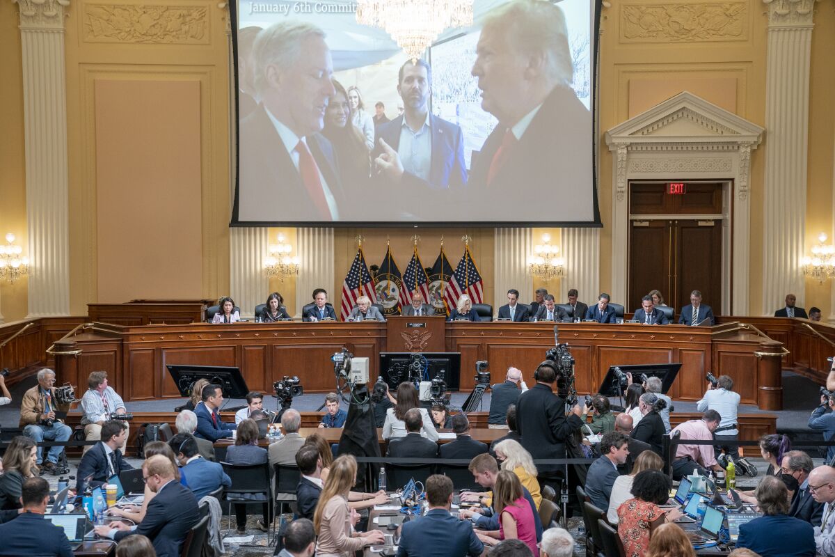 An image of President Trump and Mark Meadows is projected on a screen at a House committee hearing.
