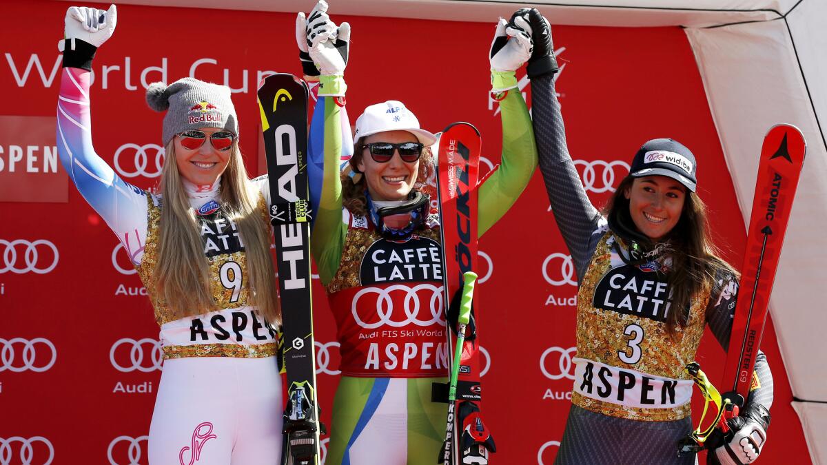 Downhill race winner Ilka Stuhec is flanked by runner-up Lindsey Vonn, left, and third-placer Sofia Goggia on the podium Wednesday in Aspen, Colo.