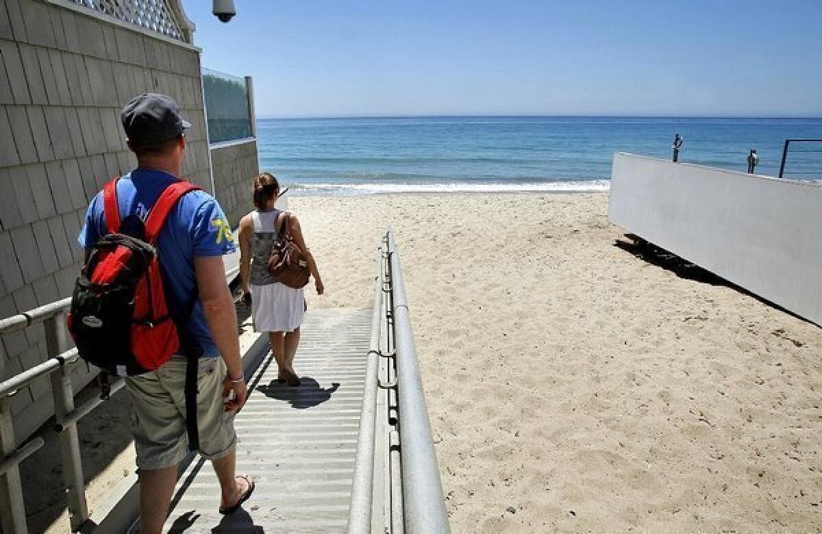 Tourists access Carbon Beach in Malibu through a public accessway alongside David Geffen's home on Monday. Malibu residents say beachgoers often trash the areas in front of their homes.