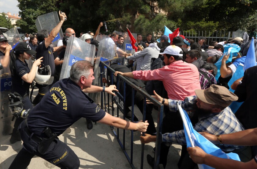 Riot police use pepper spray to push back ethnic Uighur protesters trying to break through a barricade outside the Chinese Embassy in Ankara, Turkey, on June 9.
