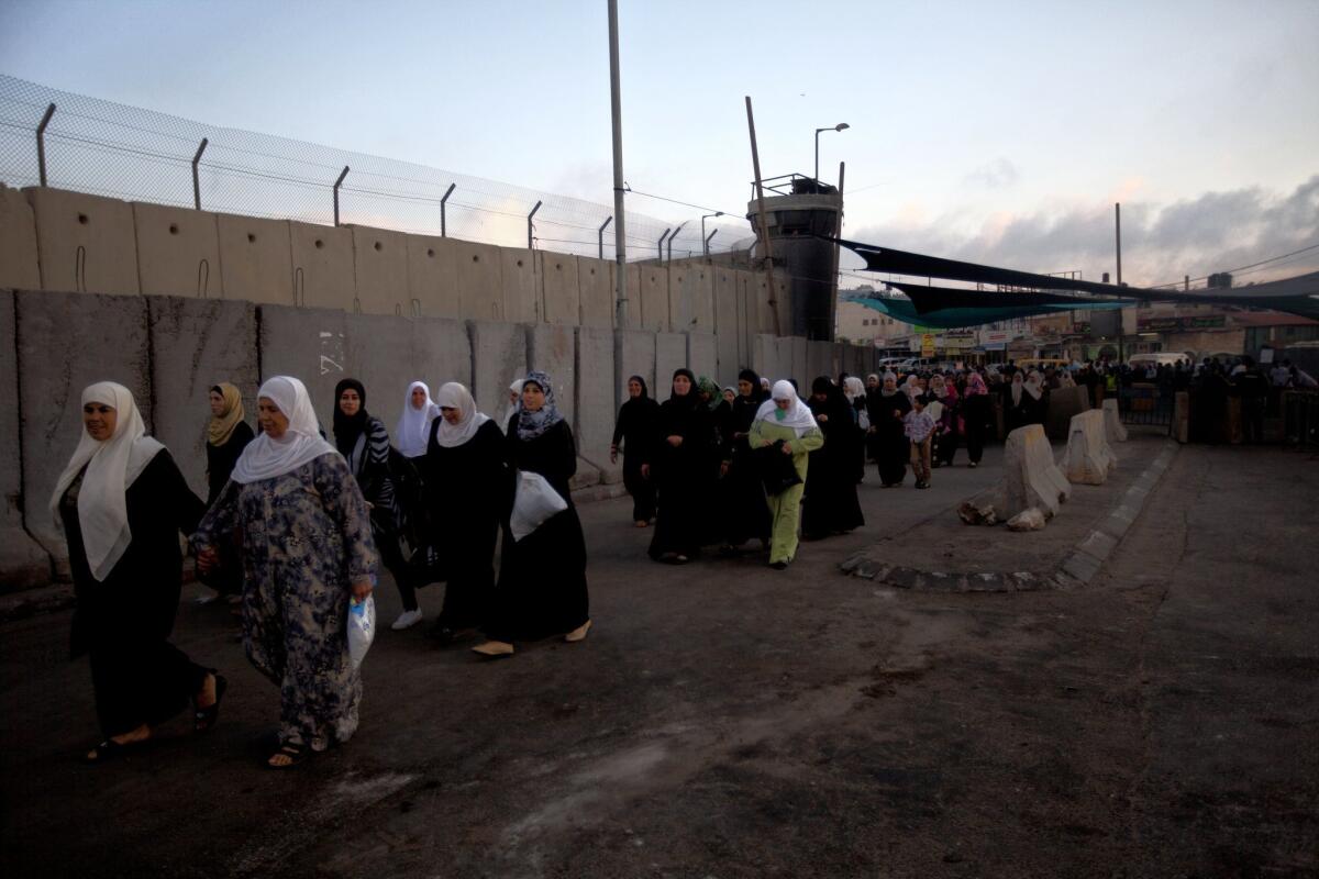 Palestinian women cross the Qalandia checkpoint, between the West Bank city of Ramallah and Jerusalem, on their way to pray at the Al Aqsa Mosque during the Muslim holy month of Ramadan.