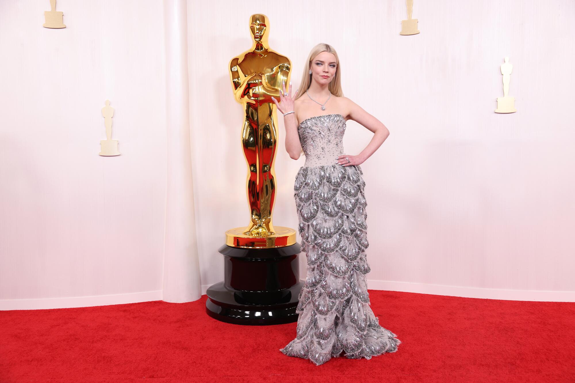 Anya Taylor-Joy wears a strapless silver dress with scalloped layers. 