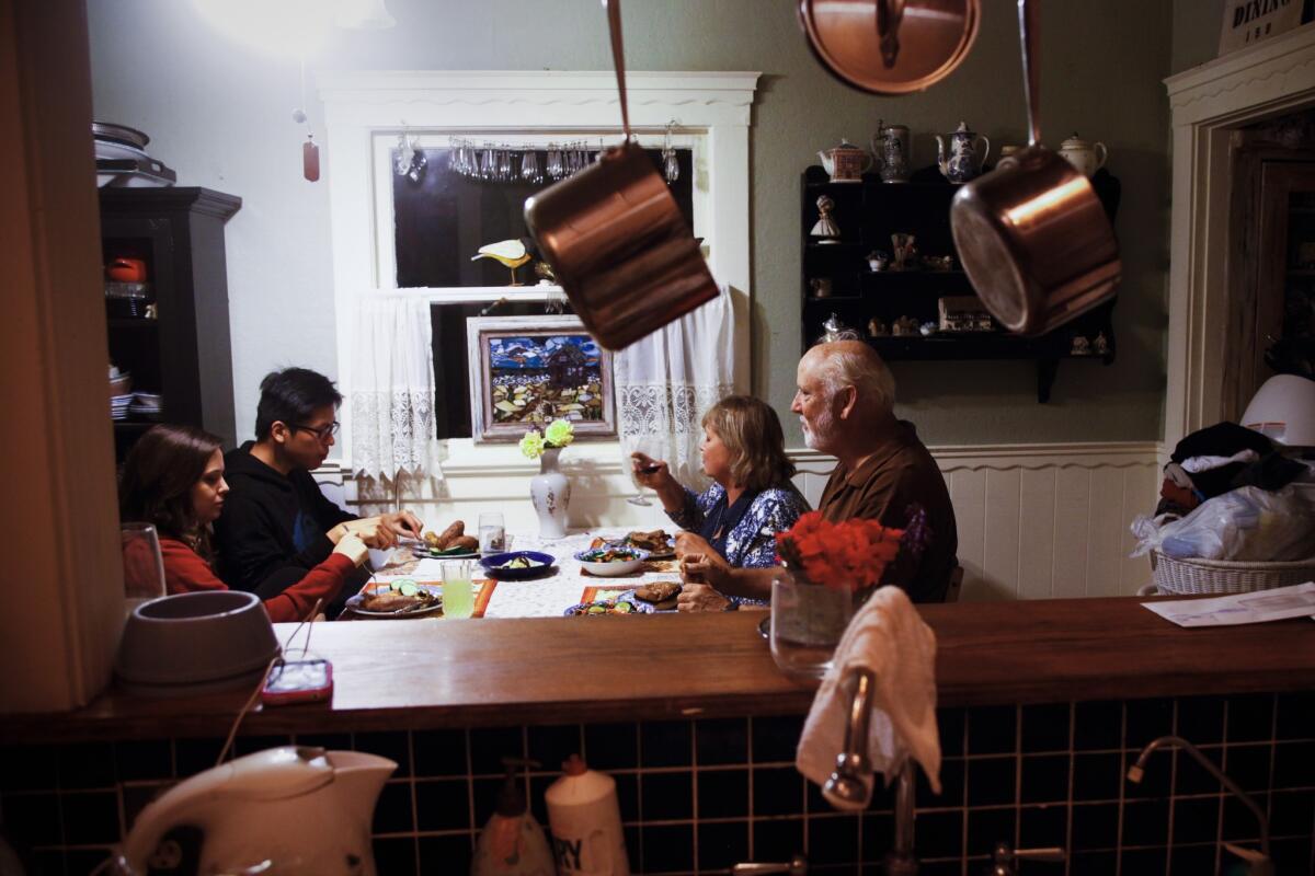 The family eats dinner together. Janet Barker, third from left, no longer dreams about early retirement, but she does speak optimistically about her daughter's future.
