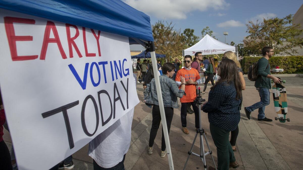 Democrats at UC Irvine encourage voters to cast their ballot at an early voting center on Oct. 30, 2018. Orange County, along with four other counties, will formally enact the early voting options under the California Voter's Choice Act in 2020.