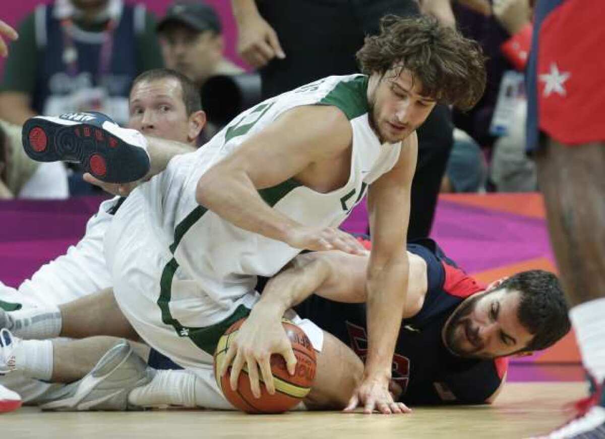 Kevin Love, right, of the U.S. and Simas Jasaitis of Lithuania hit the floor battling for a loose ball in the first half Saturday.