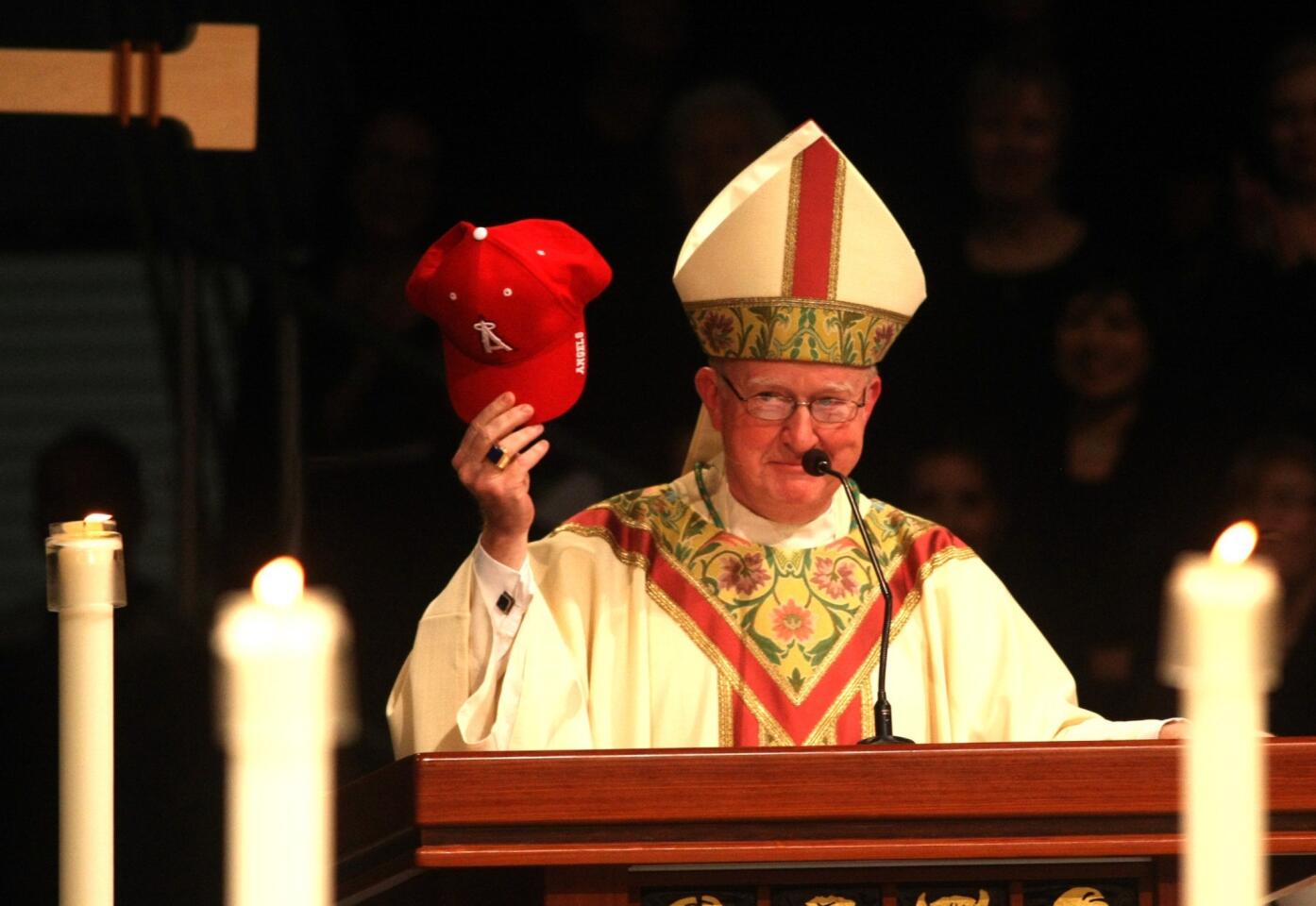 Bishop Kevin W. Vann, 61, holds up a Los Angeles Angels of Anaheim baseball cap during his speech to congregants at his installation as the new bishop of the Diocese of Orange.