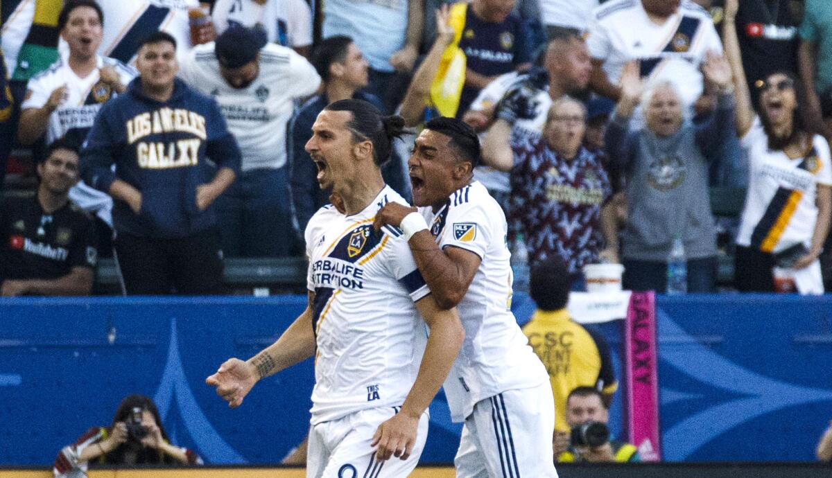 Galaxy forward Zlatan Ibrahimovic celebrates with defender Julian Araujo after scoring a goal in the first half of the game against LAFC on Friday night.