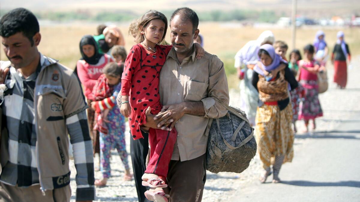 Fleeing Yazidis cross the border from Iraqi into Syria in 2014 after their villages were attacked by Islamic State.