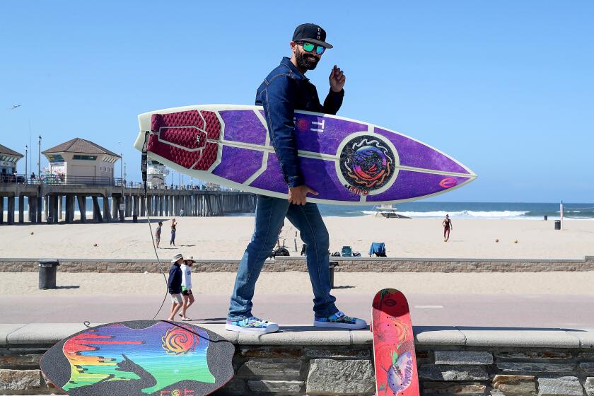 Founder Timo Tidwell, stands with his board with the TIOIT surf grip on the deck.
