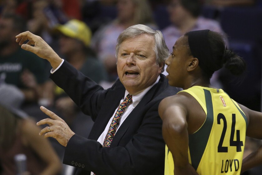 FILE - Seattle Storm coach Dan Hughes, left, talks with guard Jewell Loyd during the second half of the team's WNBA basketball game against the Phoenix Mercury in Phoenix, in this Tuesday, Sept. 3, 2019, file photo. Last season, Dan Hughes wasn't allowed to be on the sideline, forced to watch the Seattle Storm roll to a WNBA title from afar. The head coach of the Storm is back as Seattle begins its quest for back-to-back titles. In many ways, Hughes' return makes the Storm whole for the first time since 2018. (AP Photo/Ross D. Franklin, File)