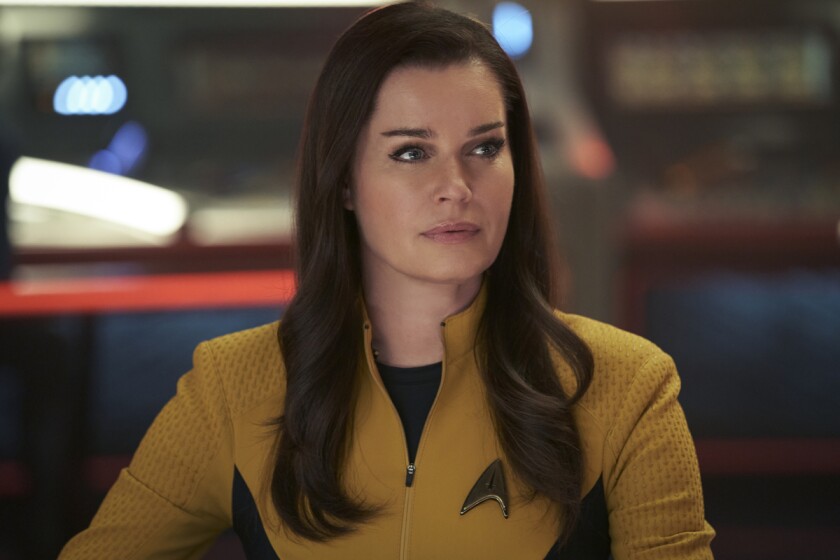 A woman in a yellow Star Trek uniform.