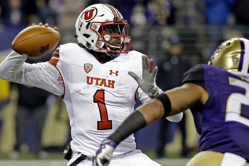 Utah quarterback Tyler Huntley (1) readies a pass as Washington defender Ezekiel Turner moves in during the first half of an NCAA college football game Saturday, Nov. 18, 2017, in Seattle. (AP Photo/Elaine Thompson)