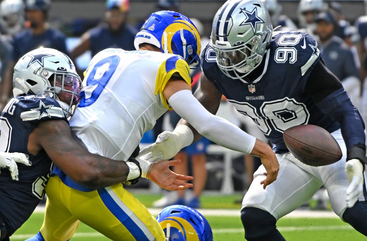 The Rams' Matthew Stafford fumbles the ball on a hit by Dallas' Dorance Armstrong before DeMarcus Lawrence (90) recovers it