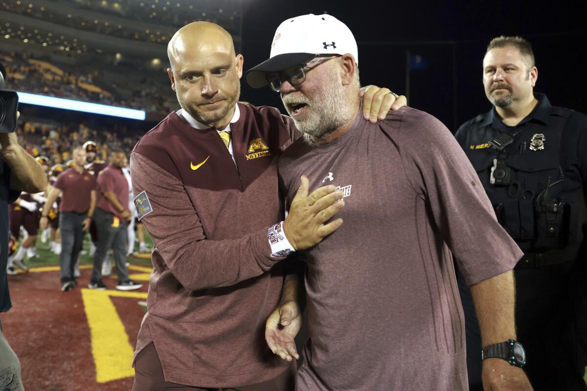 Minnesota coach P. J. Fleck, left, and New Mexico State coach Jerry Kill, right, congratulate each other after Minnesota defeated New Mexico State 38-0 during an NCAA college football game Thursday, Sept. 1, 2022, in Minneapolis. (AP Photo/Abbie Parr)