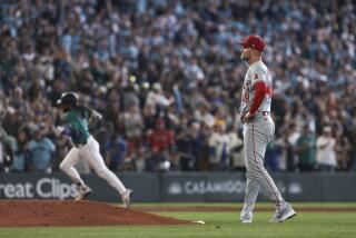 Los Angeles Angels starting pitcher Reid Detmers, right, waits as Seattle Mariners' J.P. Crawford.