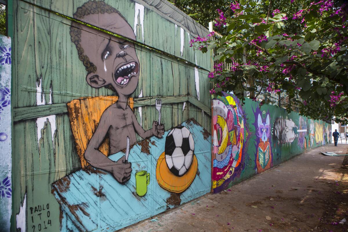 Graffiti of a crying child who is served a soccer ball to appease his hunger covers a portion of a public school wall in Sao Paulo.
