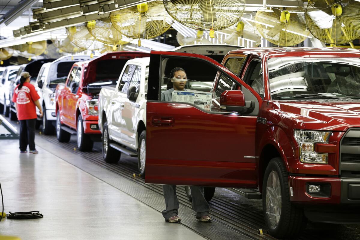 Ford workers inspect 2015 aluminum-alloy body Ford F-150 trucks at the company's plant in Claycomo, Mo., in March.