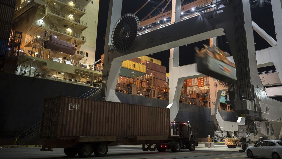 A crane loads a 40-foot shipping container onto a container ship at the Port of Savannah in Georgia.