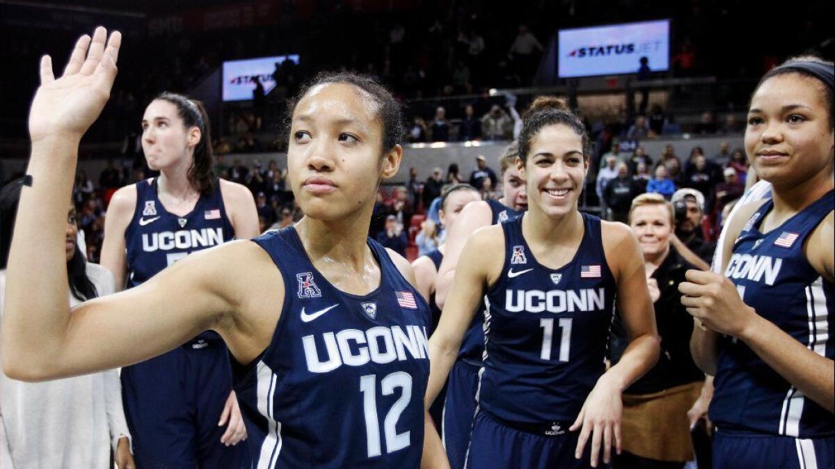 Connecticut guard Saniya Chong (12) and her teammates wave to fans after a defeating SMU, 88-48, for their 91st straight win.