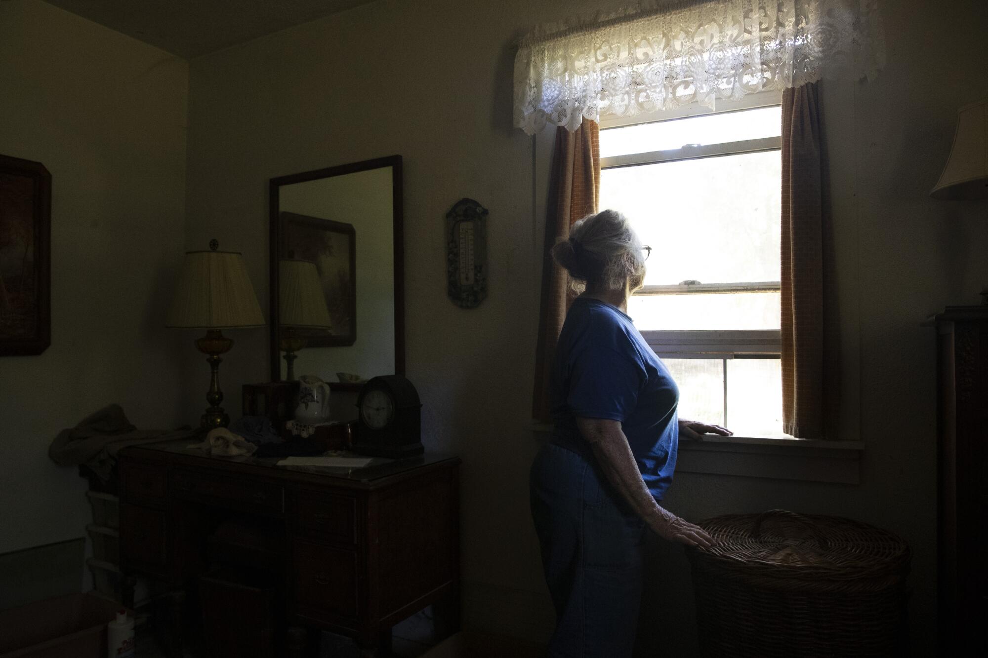 A Mendocino County resident looks out her bedroom window.