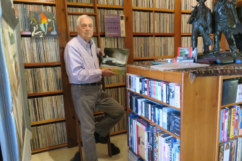 Bram Dijkstra poses with some of his nearly 50,000 albums, which he is donating to San Diego State University.