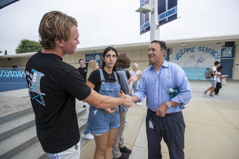 Newport Beach, CA - August 22: ASB President TJ Rokos shakes with the new principal Jake Haley as the the ASB Vice President Ella Avital, 17, looks on during the first day of school at Corona del Mar High School and Middle School on Monday, Aug. 22, 2022 in Newport Beach CA. (Scott Smeltzer / Daily Pilot)